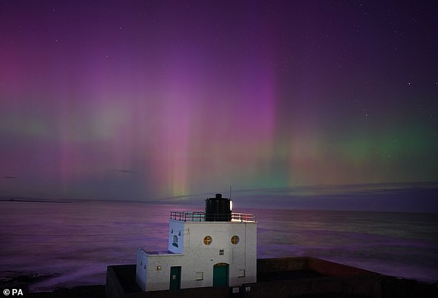 The Northern Lights appear over Bamburgh Lighthouse in Northumberland, on the northeast coast of England, on November 5, 2023.