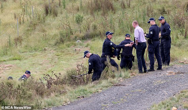Police are seen searching a property on Hazelton Road in Bungonia on Tuesday.