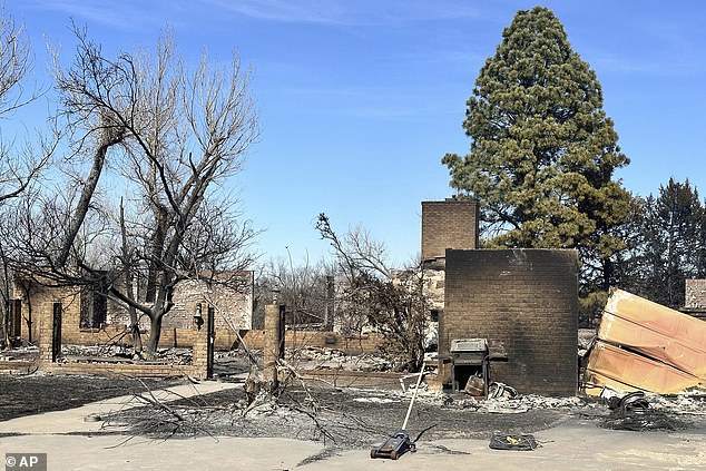The remains of a burned house smolder in Canadian, Texas, on Wednesday
