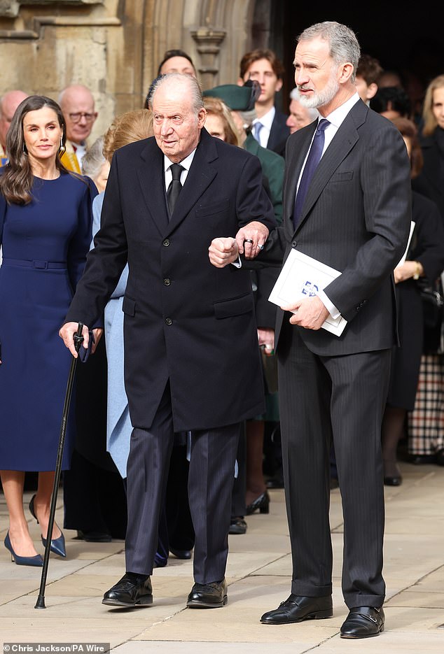 King Felipe of Spain offers an arm to his disgraced father Juan Carlos as he leaves the chapel today