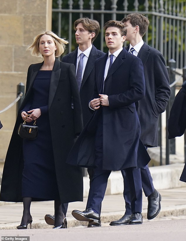 Pictured: Crown Princess Olympia of Greece wears a navy dress and oversized black coat to her grandfather's funeral in Windsor today. The Crown Princess arrived with her brothers Achileas-Andreas, Constantine Alexios and Odysseas-Kimon.