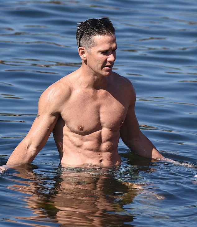 Jono's abs stood out against the deep blue of the sea.