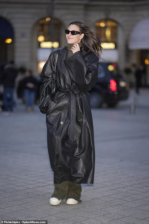 The Chanel ambassador looked effortlessly chic as she wrapped herself in a long black leather coat, adding a khaki turtleneck and matching flared pants for her solo outing.