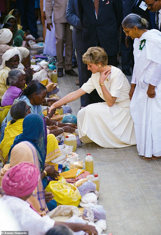 Princess Diana visits the Mianpur Aging Welfare Center in India in February 1992, wearing a cream-colored dress with a pleated skirt and gold buttons designed by Catherine Walker.
