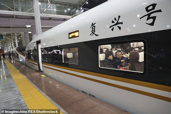 Passengers board a 'Fuxing' high-speed bullet train on the Beijing-Shanghai high-speed railway line before leaving Cangnan railway station on November 20, 2017.