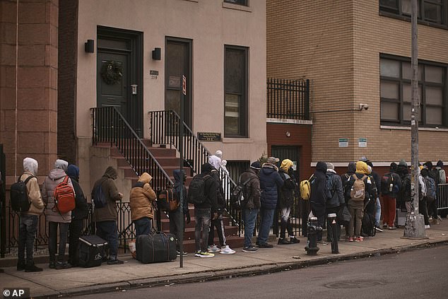 A long line of migrants is seen standing in the cold as they sought shelter outside a migrant assistance center at St. Brigid's Elementary School on December 5 in New York.