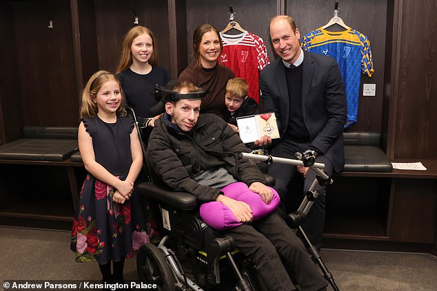 Rob and his family pictured with Prince William, who presented the sporting legend with a CBE