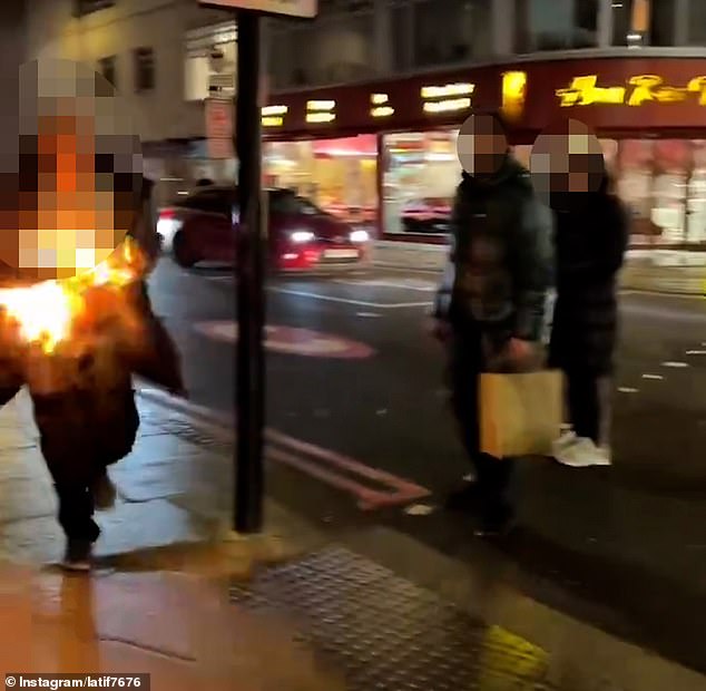 People look on in shock as the man covered in flames runs down a street on Edgware Road.