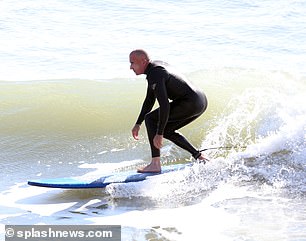 He was photographed riding a wave.