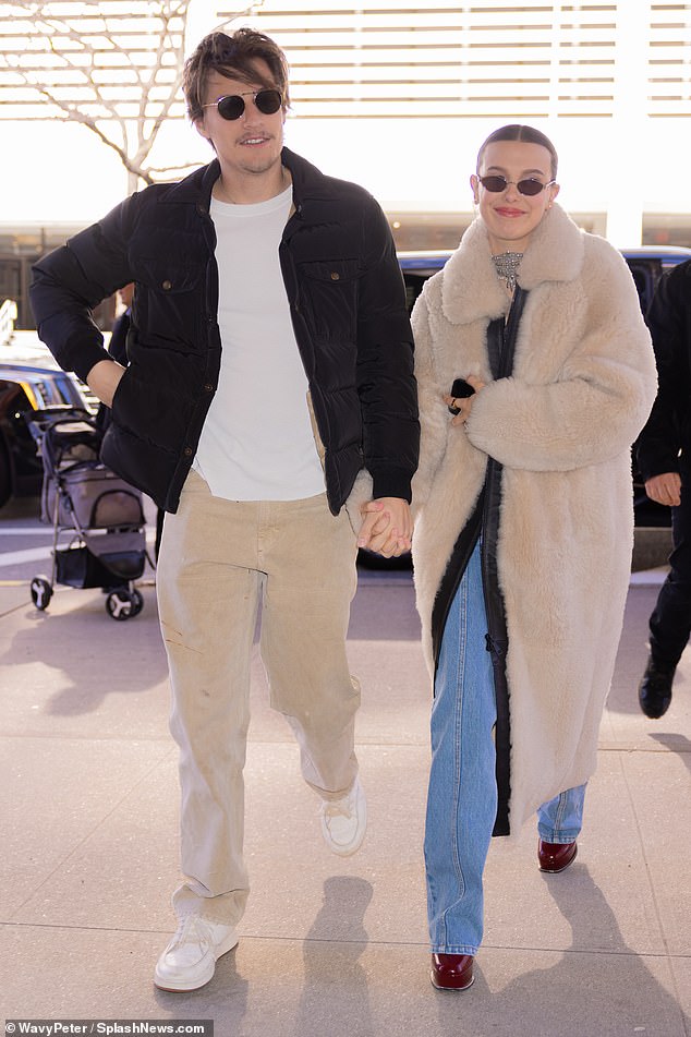 Milly covered up in a long, stylish beige coat and added a pair of narrow sunglasses.