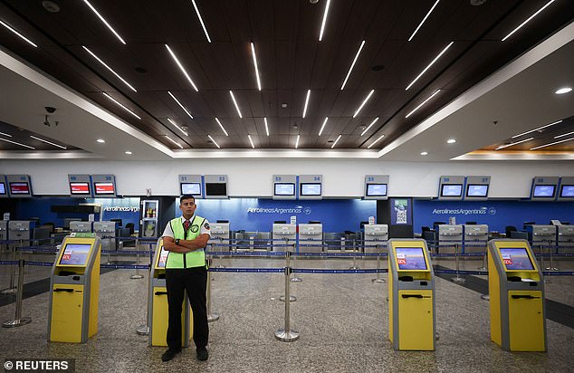 A security worker stands in front of the Aerolíneas Argentinas airline counters at Aeroparque Jorge Newbery airport in Buenos Aires on Wednesday after air transport workers went on strike across the country.  The strike has left at least 35,000 passengers stranded