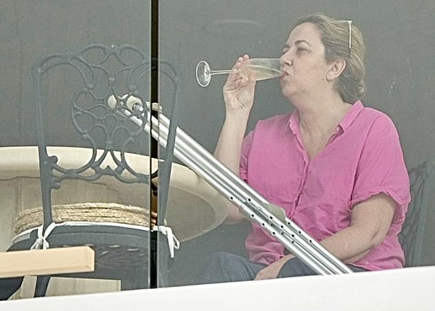 Former Queensland Premier Annastacia Palaszczuk was seen putting her crutches aside, putting her feet up and drinking a glass of champagne on the balcony of her surgeon boyfriend's apartment in Burleigh Heads on Saturday (pictured).