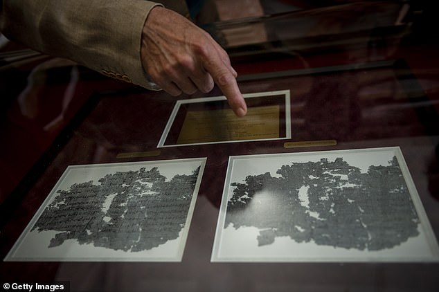 A conservator displays a Herculaneum Papyrus, charred by the eruption of Vesuvius at the National Library in Naples