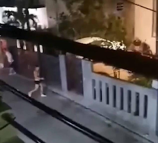Shocking footage shows naked sex workers running into the street as the two groups throw glasses and flower pots at each other over the garden wall.