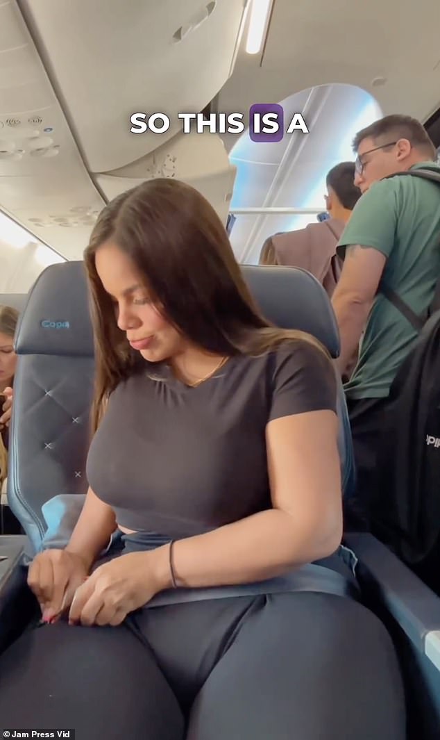 The clip shows the 26-year-old plus-size woman pouting on the plane as she struggles to put on her seatbelt.