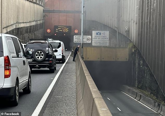 The car fire caused traffic chaos at Sydney's Eastern Distributor as emergency services stopped traffic in both directions (pictured, smoke billowing from the tunnel)