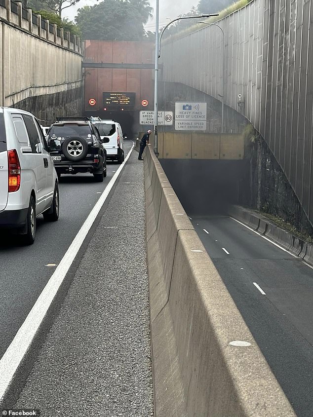 A car fire has caused traffic chaos at Sydney's Eastern Distributor as emergency services stopped traffic in both directions (pictured, smoke billowing from the tunnel)