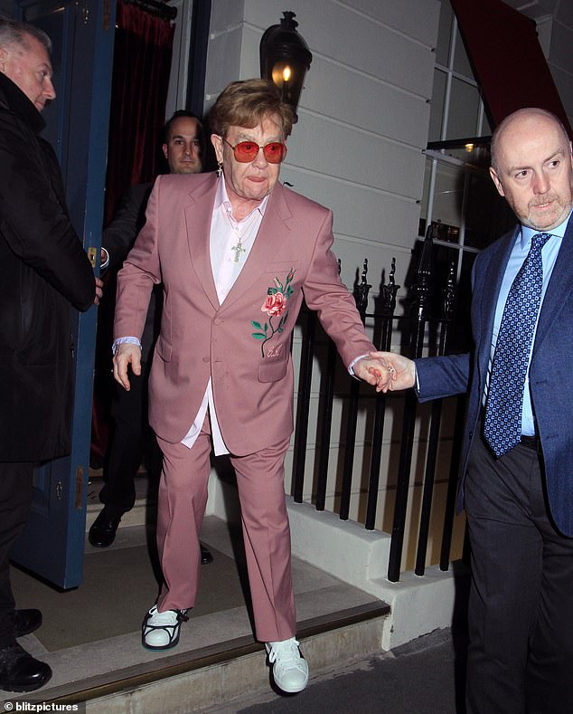 Elton John struggled to walk as he left a fancy dinner in London with a foot brace on Tuesday night.