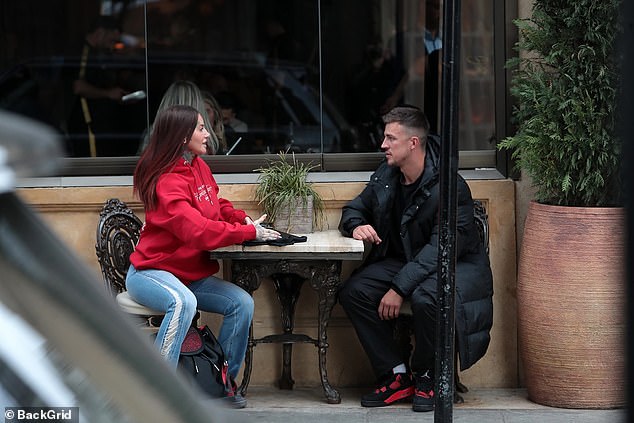 Jemma cut a casual figure in a red hoodie and ripped flared jeans which she teamed with a crossbody bag and black sneakers.
