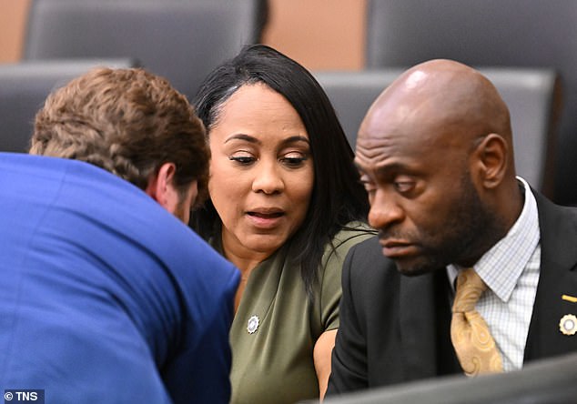 Fulton DA Fani Willis (center) speaks with lead prosecutors Donald Wakeford (left) and Nathan Wade during a hearing at the Fulton County Courthouse in Atlanta on Friday, July 1, 2022.