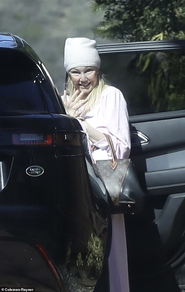 Makeup-free and looking healthy and trim, Heather was dressed for comfort in a soft pink suit and matching hat and carried a Louis Vuitton bag.
