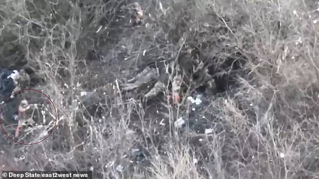 Drone video shows a suspected Russian soldier (left) raising his weapon at suspected Ukrainian soldiers (right).