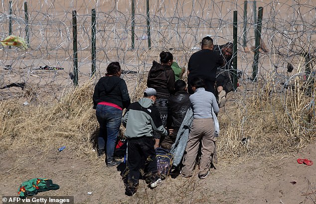 Migrants try to cut a barbed wire fence installed to prevent the entry of illegal immigrants across the Rio Bravo/Grande from Ciudad Juárez, Chihuahua state, Mexico, on February 12, 2024.
