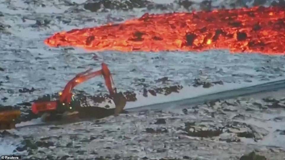 A work crew driving what appears to be an excavator leaves its exhaust extremely close, with burning orange lava near its tail.