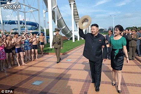 The happy couple: North Korean leader Kim Jong-un walks arm in arm with his wife Ri Sol-ju in July, before his two-month absence