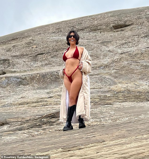 Kourtney Kardashian reveals she conceived baby Rocky with husband Travis Barker ‘one year ago’ on luxury Utah holiday… as she braves the snow in a skimpy red bikini