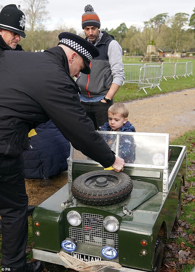 A little boy who arrived in a toy car to see King Charles during his visit to a church service in Sandringham appeared to have his first brush with the law, after an officer jokingly handed him a mock parking ticket.