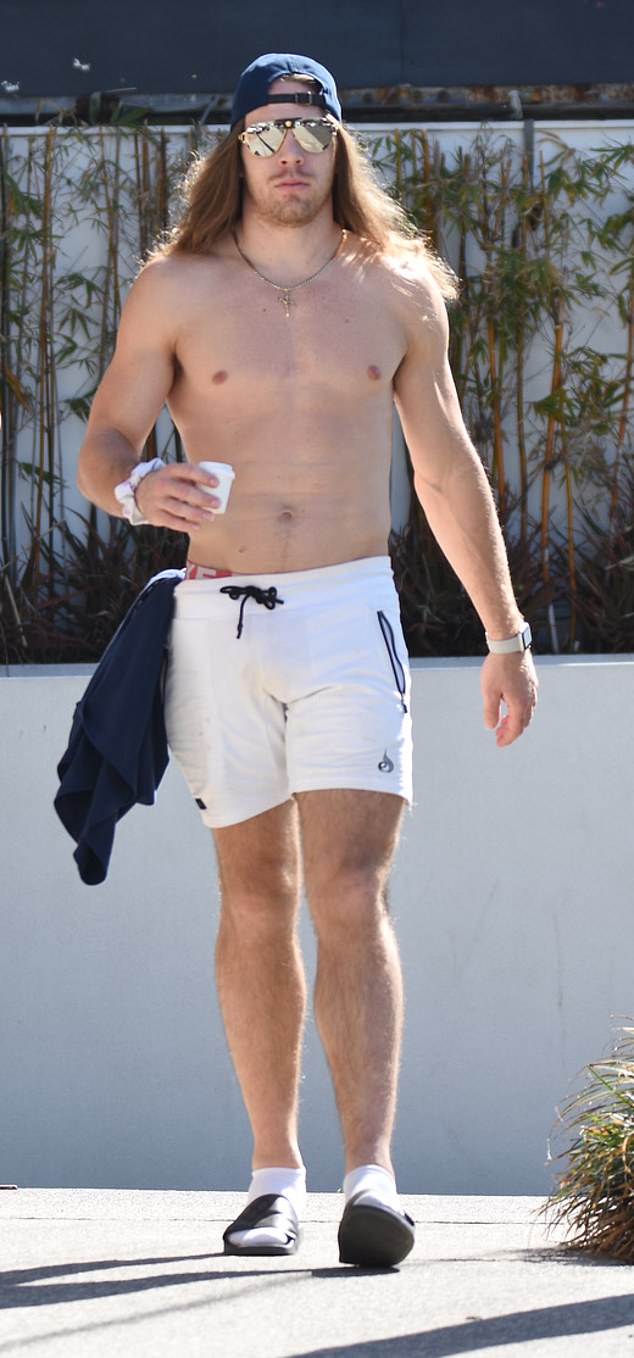 Professional kickboxer Jayden made the most of his silhouette in a pair of white trunks. He accessorized his look with a blue backwards cap and reflective sunglasses.