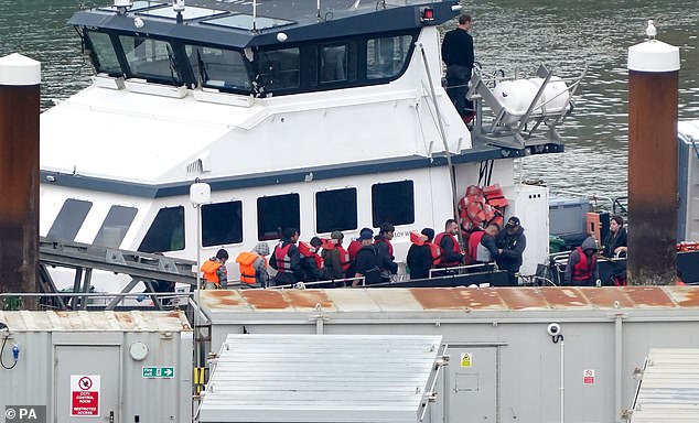 A group of people believed to be migrants are taken to Dover, Kent, from a Border Force ship after being rescued during a small boat incident in the English Channel on Friday.