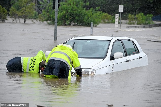 A 28-year-old woman died after her car was submerged in the flooded Malbon River at Duchess, north-west Queensland, about 1pm on Thursday (pictured, car trapped in Brisbane floods ).