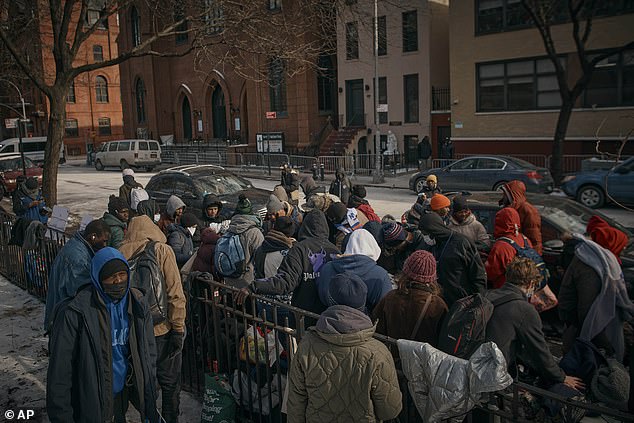 Migrants collect clothing as mutual aid groups distribute food and clothing in cold weather near the Migrant Assistance Center at St. Brigid's Elementary School last month in New York.