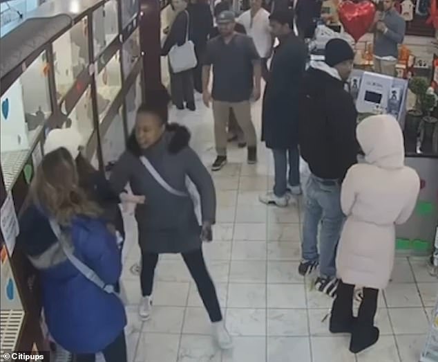 A crazed woman (pictured in the gray coat) was caught brutally slapping a tourist after allegedly kicking kennels inside a New York City pet store over the weekend.