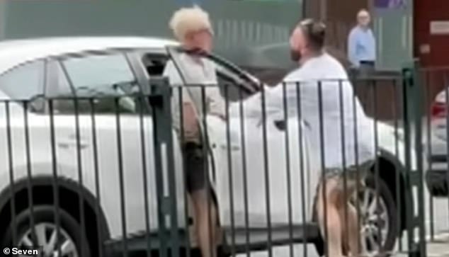 A sneaky road rage incident on the Pacific Highway in Sydney's north was caught on camera and appears to show a man being crushed by a car door and spat on (pictured).