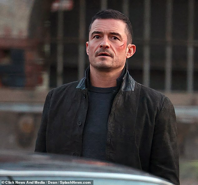 Orlando Bloom sported a large gash on his cheek while filming scenes for the new Amazon Prime original Deep Cover in London on Wednesday.