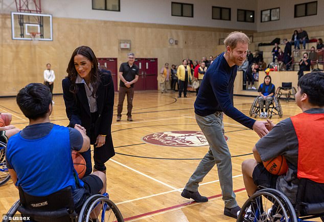 Prince Harry and Meghan shake hands with players before the wheelchair basketball game at the Mount Currie Community Center in British Columbia on Thursday.
