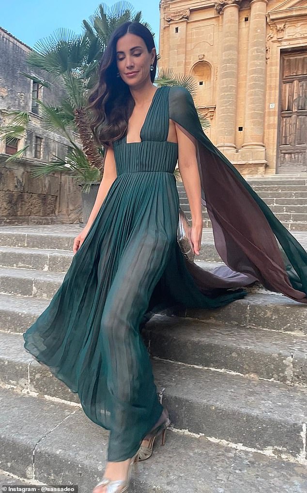 Alessandra exudes glamor in an emerald green Dior cape dress