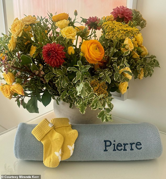 The 40-year-old supermodel shared an image of a blue baby blanket embroidered with her newborn son's name, as well as an adorable pair of yellow knit booties.
