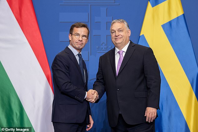 Swedish Prime Minister Ulf Kristersson and Hungarian Prime Minister Viktor Orban shake hands after a news conference following their meeting in Budapest, Hungary, on Friday.