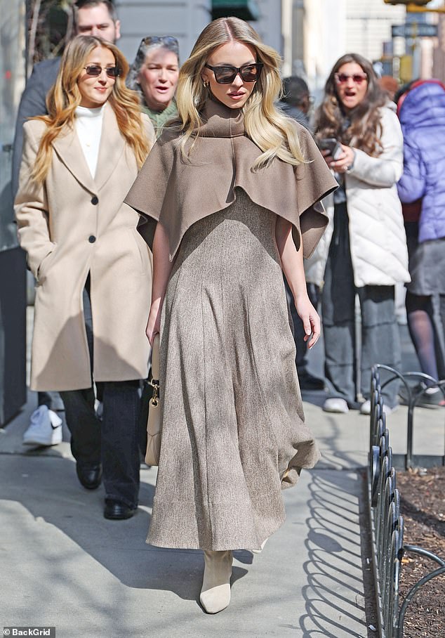 Sydney Sweeney looked straight out of another era in a classic beige dress with a long, pleated A-line skirt. The Everyone But You star, 26, paired the elegant dress with a cape in a warmer, matching shade of beige.