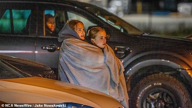 A couple of determined Swifites huddle under a blanket to beat Melbourne's 14 degree weather on Friday as they hope to catch a glimpse of Taylor (pictured).