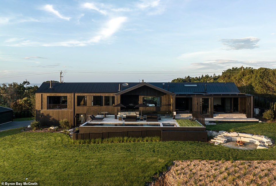 Located on top of a hill in a picturesque rural setting is a rustic-style estate with an all-black facade and interior that captivates home lovers with its elegant minimalist style.