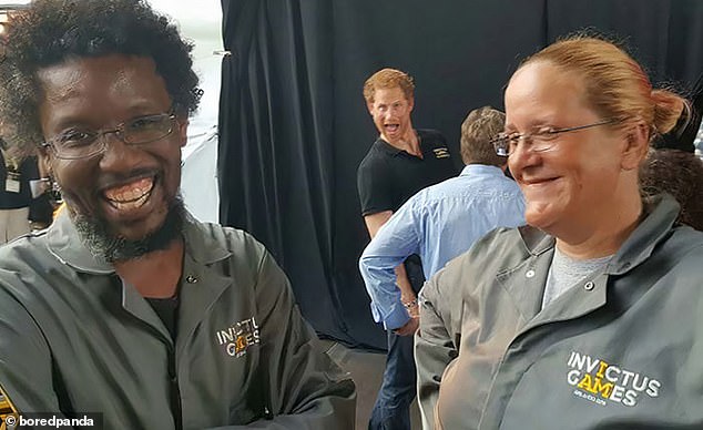 Happy as Harry!  The Duke of Sussex showed off his goofy side as he stuck his tongue out behind two Invictus Games workers in this snap taken in Toronto.