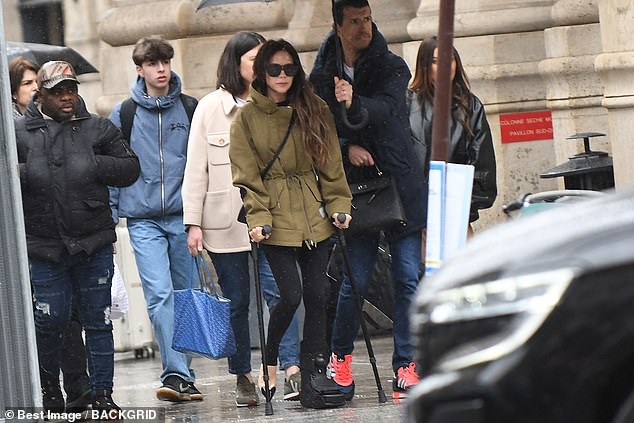 Victoria Beckham continued walking with crutches as she left for Paris on Monday morning following her recent injury.