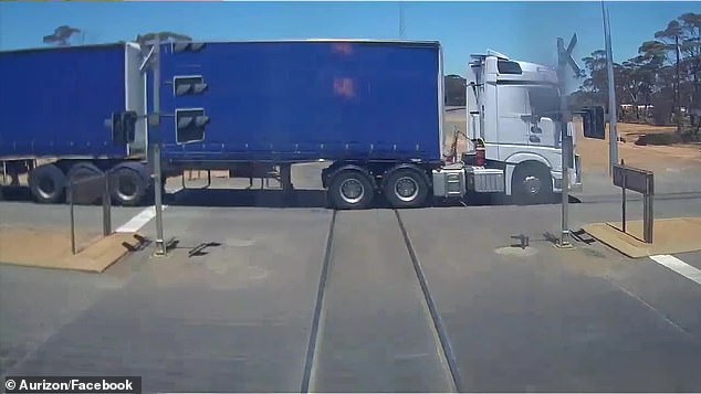 A train narrowly avoided a catastrophe on Saturday when a truck (pictured) sped through a railway crossing, with the driver apparently unaware that they were seconds away from almost certain death.