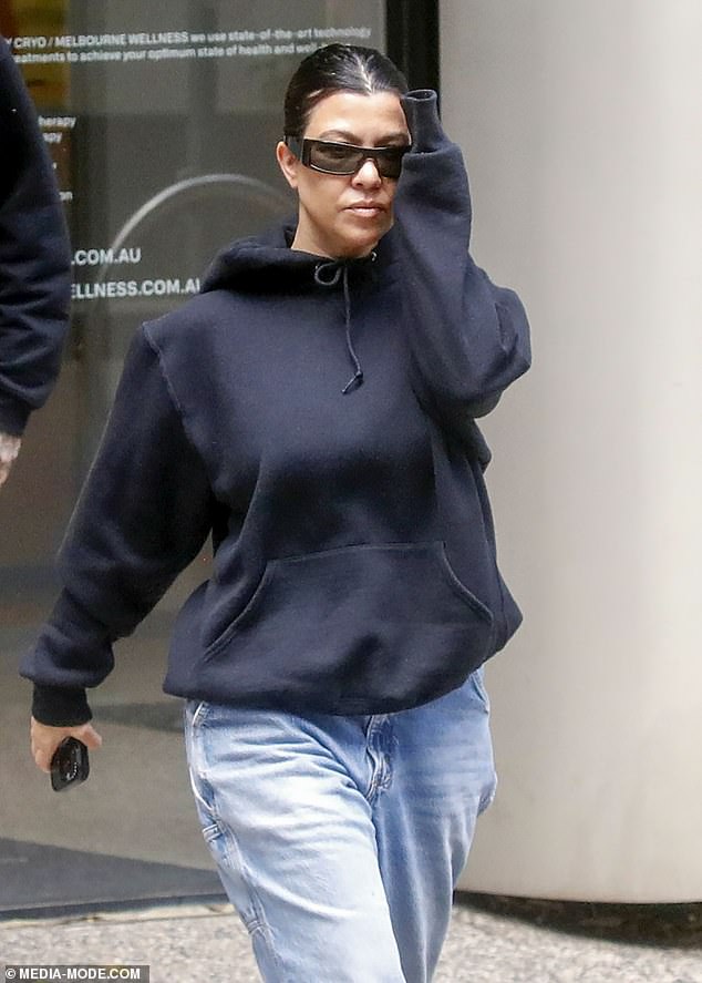 The Kardashian star paired the look with sunglasses and tied her brunette locks into a bun.