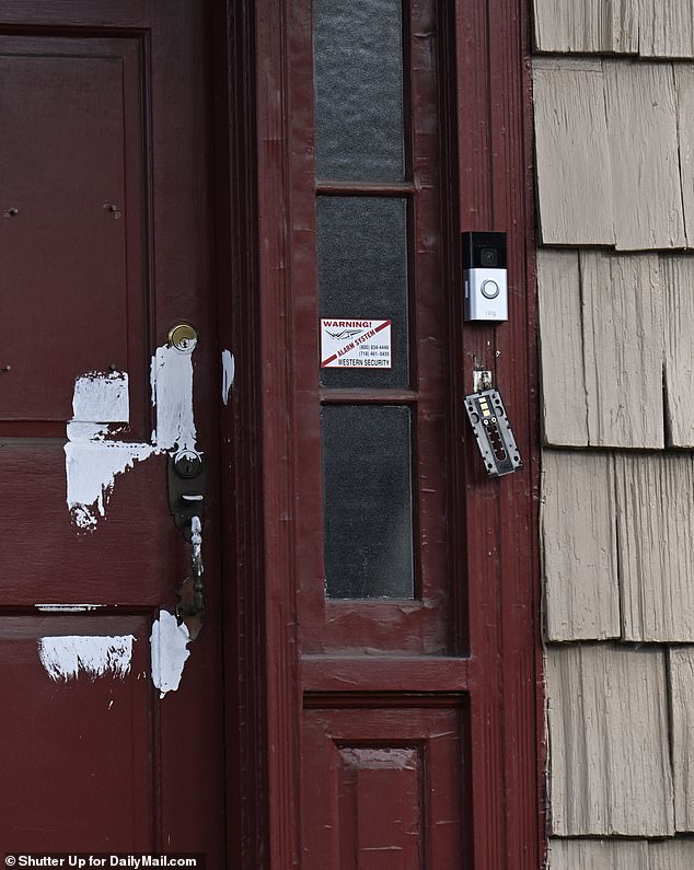 Scattered, unfinished white paint was also left on the home's red front door, along with a keyed lock bracket that had been ripped off its hinges.